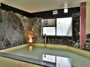 大町市にあるＧｕｅｓｔ Ｈｏｕｓｅ Ｔａｋｅｎｏｙａ - Vacation STAY 76200vの石壁のスイミングプール(大きな鏡付)