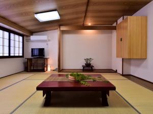 sala de estar con mesa y TV en Ｇｕｅｓｔ Ｈｏｕｓｅ Ｔａｋｅｎｏｙａ - Vacation STAY 76200v en Omachi