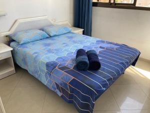 un letto con due rotoli neri di nesia di Bel appartement Kikar Hatzmaout, centre et plage a Netanya