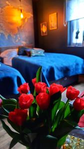 een vaas met rode rozen op een tafel in een kamer bij Sasaki Sauna i Bania in Szczutków