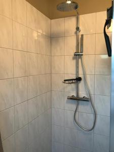 a shower with a shower head in a bathroom at Hei-d-Away in Otterlo