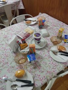 une table avec des assiettes de nourriture au-dessus dans l'établissement HOSTAL AYELEN, à Punta Arenas