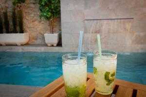 dos bebidas sentadas en una mesa junto a una piscina en Casa Amparo - Alquiler íntegro con encanto en Alicante, en Alcoleja