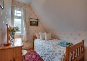 a small bedroom with a bed and a window at The Orchard in Seaton