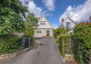 a white house with a gate and a driveway at The Orchard in Seaton