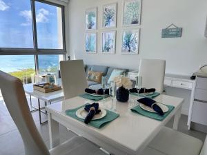 a kitchen and dining room with a white table and chairs at Azure 515 Aruba Vacation Sunset Breeze in Palm-Eagle Beach