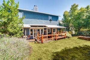 a blue house with a large deck in the yard at Historic Seattle Vacation Rental in Seward Park! in Seattle