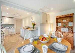 a kitchen with a wooden table with a bowl of fruit on it at Bryn Penmaen in Pwllheli