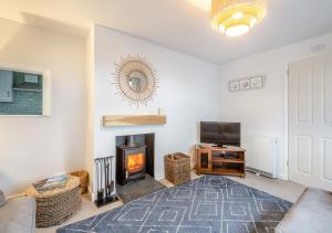a living room with a fireplace and a tv at Bryn Penmaen in Pwllheli