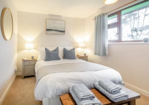 a bedroom with a large bed with two towels on it at Bryn Penmaen in Pwllheli