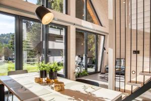 uma sala de jantar com uma mesa e janelas grandes em Chalet Belveder Železná Ruda em Železná Ruda