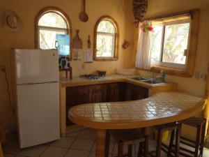 uma cozinha com um frigorífico branco e uma mesa em Hacienda Jaqueline em Sayulita