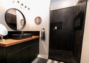 ein schwarzes Bad mit einem Waschbecken und einem Spiegel in der Unterkunft Beautiful Home w amazing views in Victoria