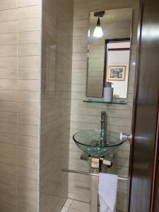 a bathroom with a glass sink and a mirror at Hostal Luxury Bogota in Bogotá