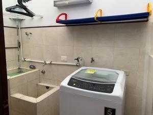 y baño con espejo y lavadora. en Hostal Luxury Bogota, en Bogotá