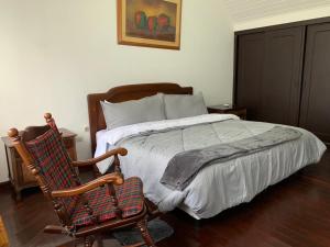 1 dormitorio con cama y mecedora en Hostal Luxury Bogota, en Bogotá