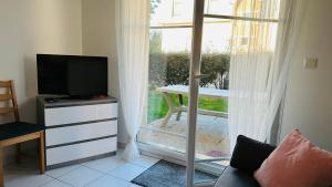 un soggiorno con TV e finestra di Superbe appartement En baie de Somme a Cayeux-sur-Mer