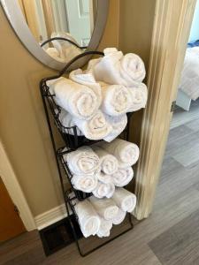 una pila de toallas en un toallero frente a un espejo en 3 Bedroom Near downtown Ottawa en Ottawa