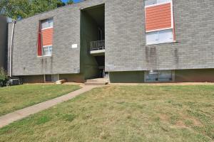 a gray house with an open door and a yard at Convenient Athens Condo with Patio about 3 Mi to UGA! in Athens