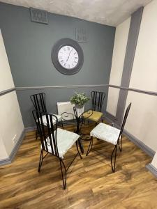 a dining room with a table and chairs and a clock at Charlesworth House in Crewe +30 photos