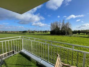 a balcony with a white fence and a green field at 3 Bedroom Apartment with Golf Course View in Newcastle upon Tyne