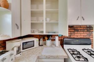 a kitchen with white cabinets and a stove top oven at Idyllic Rochester Apartment 2 Miles to Downtown! in Rochester