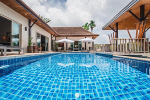 a swimming pool in front of a villa at Ivory Pool Villa in Nai Harn in Rawai Beach