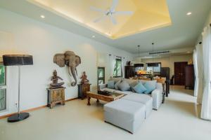 a living room with a white couch and an elephant on the wall at Ivory Pool Villa in Nai Harn in Rawai Beach