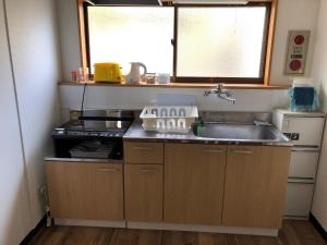 磐城的住宿－Guesthouse & Kitchen Hace - Vacation STAY 68911v，一间带水槽和炉灶的小厨房