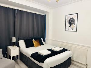 um quarto com uma cama a preto e branco em Lovely 4 Bedroom House with 2 Bathroom, Garden and Private Parking em Thornton Heath