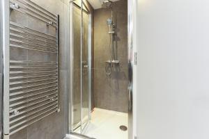 a shower with a glass door in a bathroom at Luxury 3-Bed Apartment - Sheffield City Centre - Netflix, WIFI, Radio, Interactive Mood Lighting, State of the Art in Sheffield