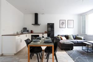 una cucina e un soggiorno con un tavolo e un divano di Superbe appartement proche gare a Tolone