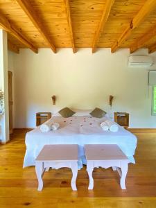 a white bed in a room with a wooden ceiling at Momentos del Espera in Tigre