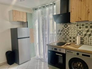 uma cozinha com um frigorífico branco e um fogão em Quartier de l'Hôtel des Bains em Moirans