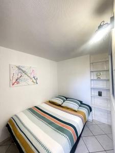 a bedroom with a bed with two pillows on it at Quartier de l'Hôtel des Bains in Moirans