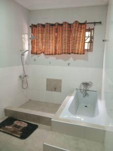 een witte badkamer met een wastafel en een raam bij Gilbert Dai Ventures in Ashalebotwe