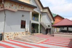 een huis met een rood en wit tapijt ervoor bij Gilbert Dai Ventures in Ashalebotwe