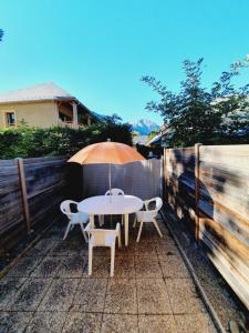 a table and chairs with an umbrella on a patio at Appartement T2 30m2 Vielle Aure in Vielle-Aure +4 photos