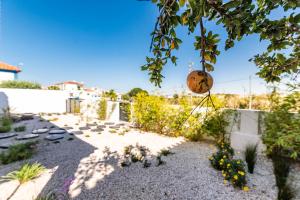 a garden with a fence and a ball hanging from a tree at Mermaid Cottage in Comporta