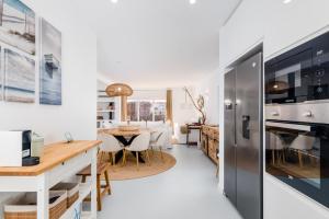 a kitchen and living room with a table and a dining room at Mermaid Cottage in Comporta