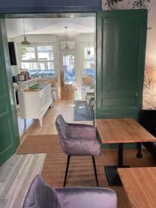 a living room with green walls and a table and chairs at Villa Artiz in Dunkerque