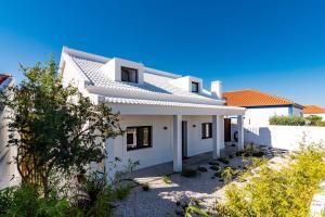 ein weißes Haus mit orangefarbenen Dächern in der Unterkunft Mermaid Cottage in Comporta