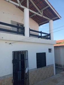 Uma casa branca com um portão à frente. em Pousada e Hostel Lua de Tomate em Caucaia