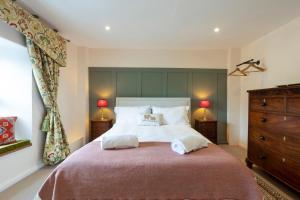 a bedroom with a large bed with two pillows at Bankside Cottage in Bedale