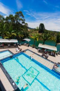 a large swimming pool with people in the water at Hotel Verony Guatape in Guatapé