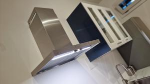 una cucina con cappa di acciaio inossidabile sopra un lavandino di Le Suites Moderne a Milano