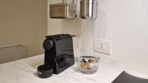 a coffee maker on a counter with a bowl of fruit at Le Suites Moderne in Milan
