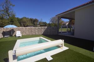 a swimming pool in a yard next to a house at Gîte D&D avec piscine privative in Martel
