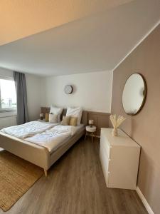 um quarto com uma cama grande e um espelho em Mango Living - Hideaway -, Dachterrasse, 77qm, 2 Schlafzimmer, 6 Personen, am Hauptbahnhof Rheydt em Mönchengladbach