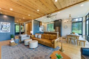 uma sala de estar com um sofá e uma mesa em Modern Turnerville Cabin with Hot Tub and Scenic Views em Thayne